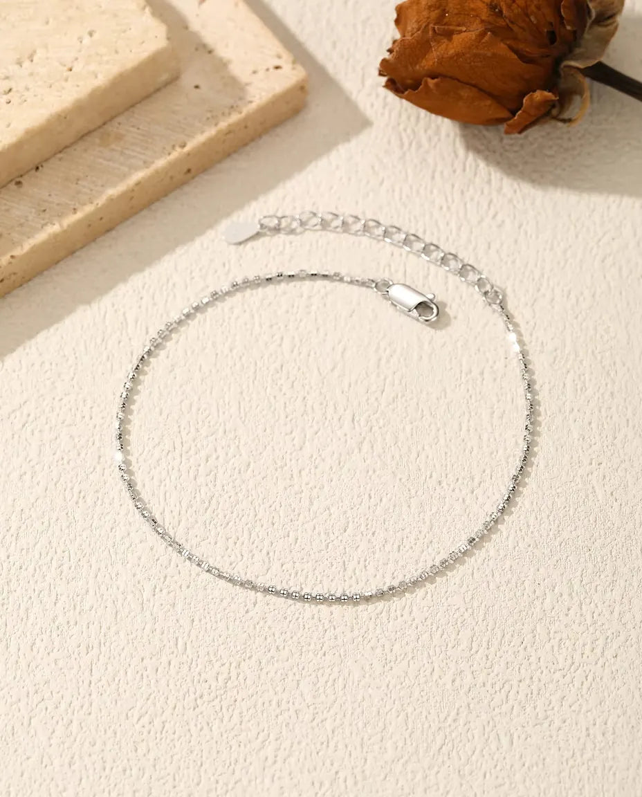 Funkelndes Armband aus 925 Sterlingsilber - flach auf heller Strukturfläche mit Verschluss und Verlängerungskette