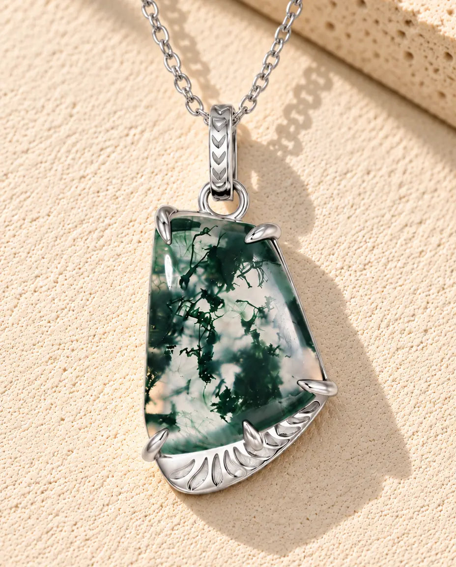 Moosachat Kette mit freier Form aus 925 Sterlingsilber - auf heller Strukturfläche neben einem Travertinblock liegend