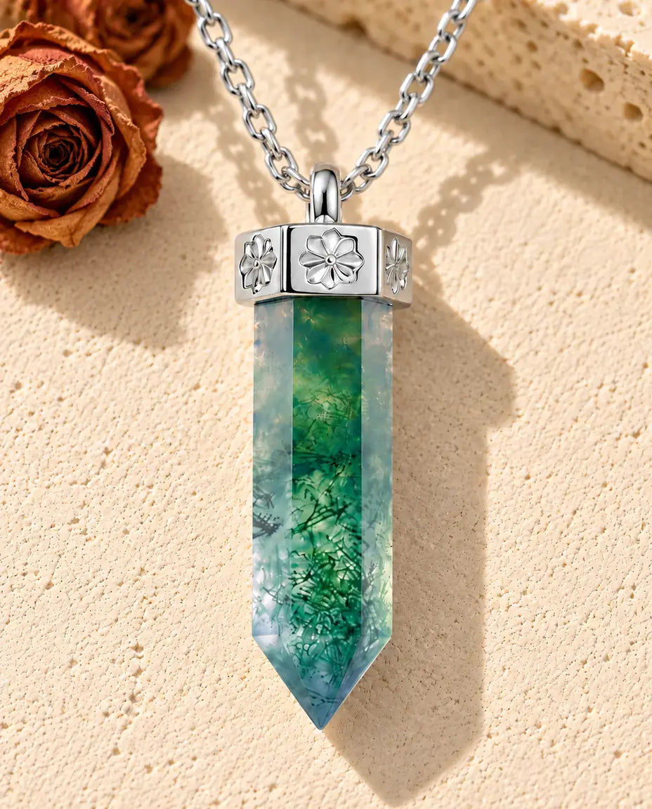 Moosachat Kette mit Spitze aus 925 Sterlingsilber - auf heller Strukturfläche neben einem Travertinblock liegend