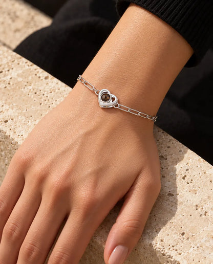 Frau trägt das silberfarbene Doppelherz-Armband mit Bild im Stein im warmen Sonnenlicht