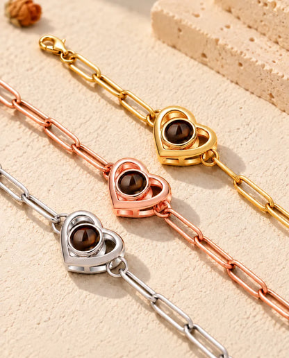Nahaufnahme von drei Doppelherz-Armbändern in Gold, Roségold und Silber