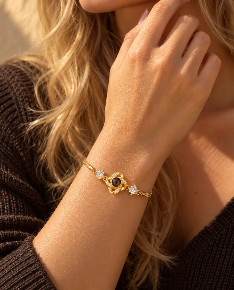 Nahaufnahme des goldfarbenen Liebesknoten-Armbands mit Zirkonia am Handgelenk nahe dem Kinn