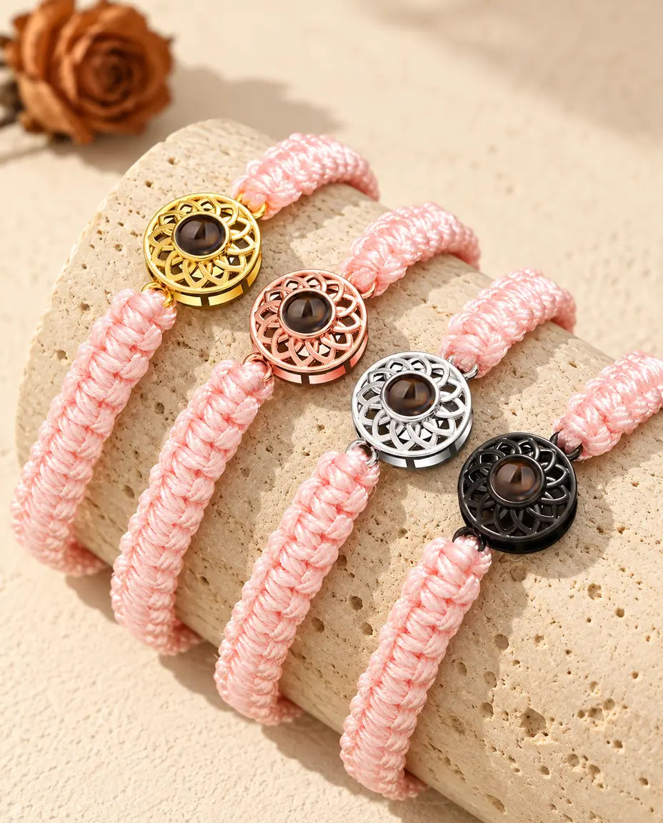 Armbänder mit rosa Flechtband und Rund-Charm in Gold, Roségold, Silber und Schwarz auf Travertin