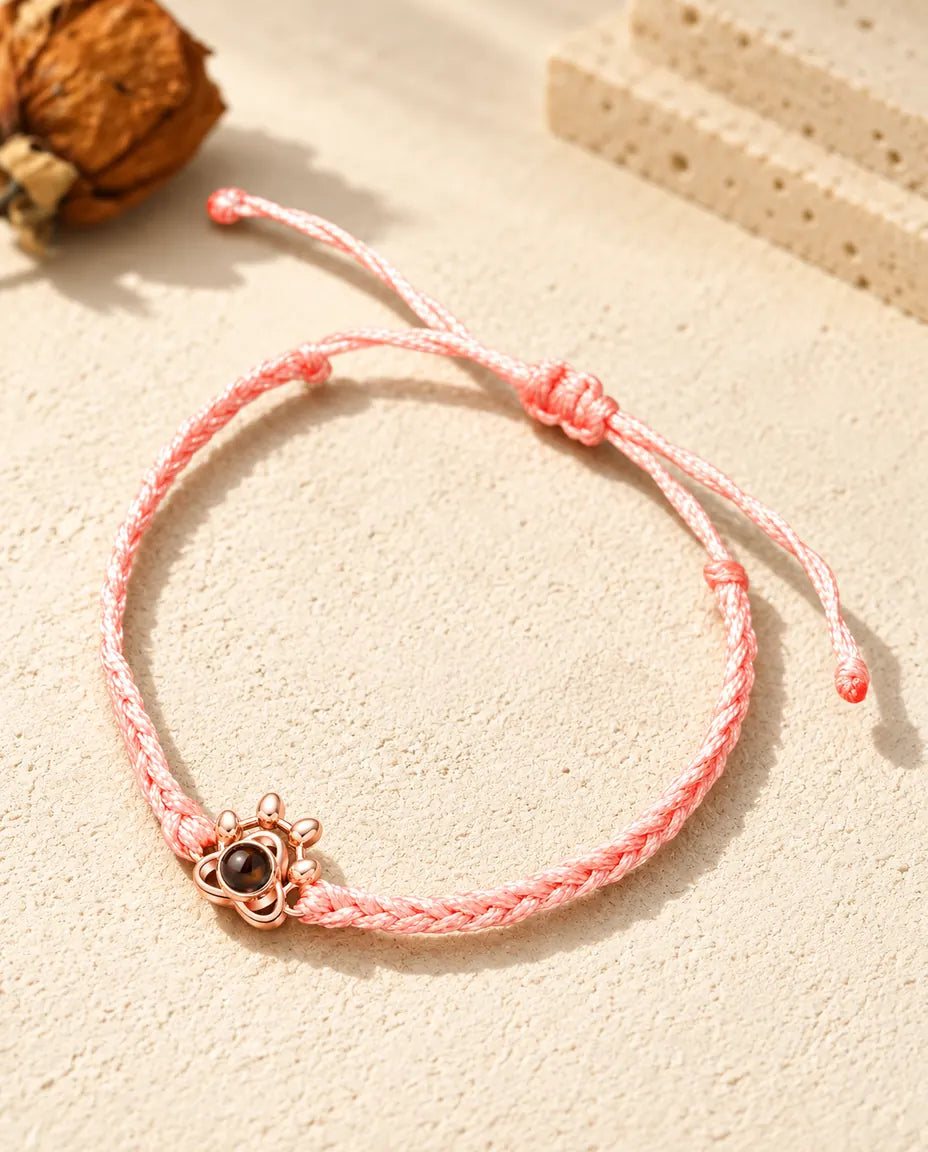 Roségoldfarbener Pfoten-Charm an rosa Flechtband mit verstellbarem Schiebeknoten