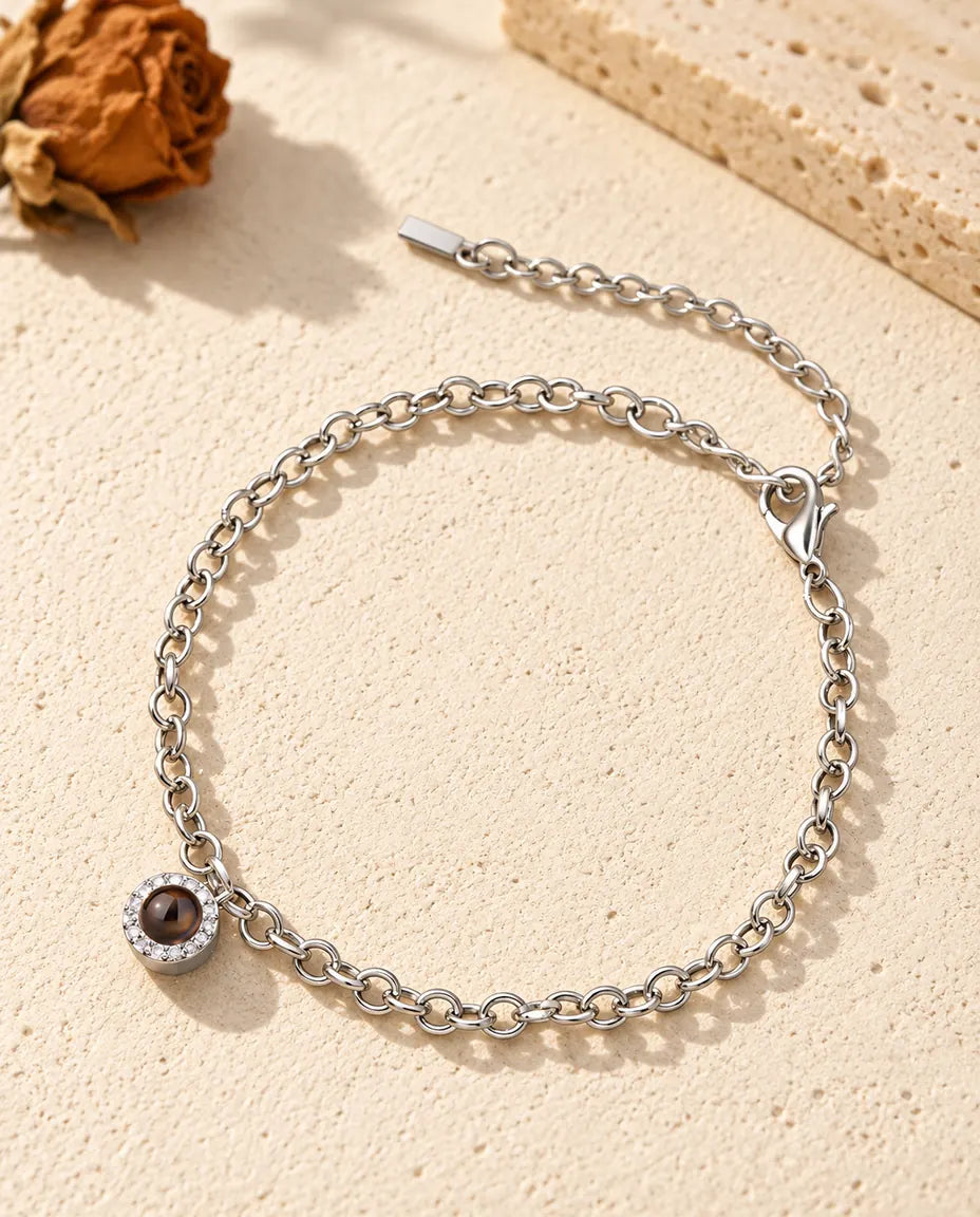 Personalisiertes Armband mit Bild im Stein, silberfarben, mit kleinem Zirkonia-Charm an feiner Kette auf Gips