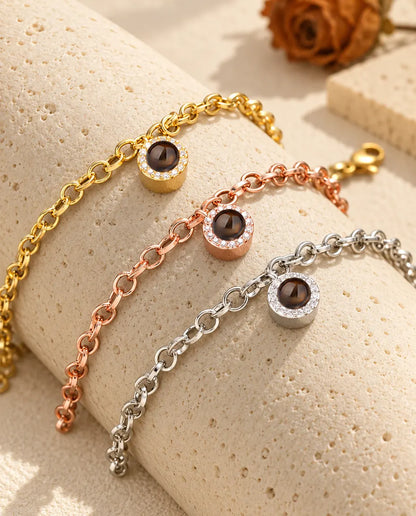 Zirkonia-Armbänder in Gold, Roségold und Silber über einem Travertinblock