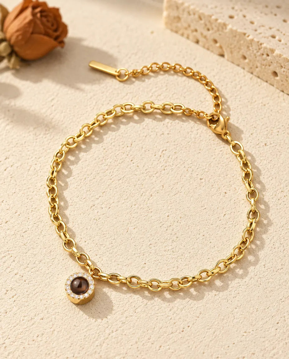 Goldfarbenes Zirkonia-Armband mit Bild im Stein auf hellem Gips
