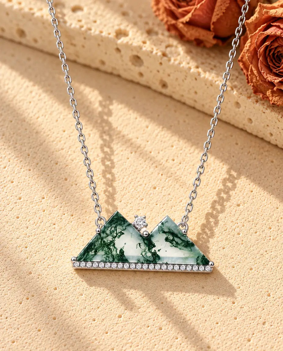 Berg Moosachat Kette aus 925 Sterlingsilber - auf heller Strukturfläche neben einem Travertinblock liegend