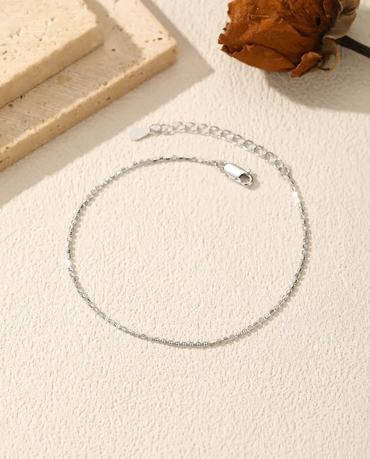 Funkelndes Armband aus 925 Sterlingsilber - flach auf heller Strukturfläche mit Verschluss und Verlängerungskette