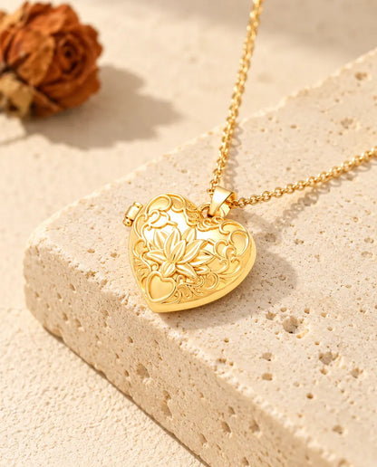Goldfarbenes Herz-Foto-Medaillon mit Lotusblüte als Kette an einem Travertinblock