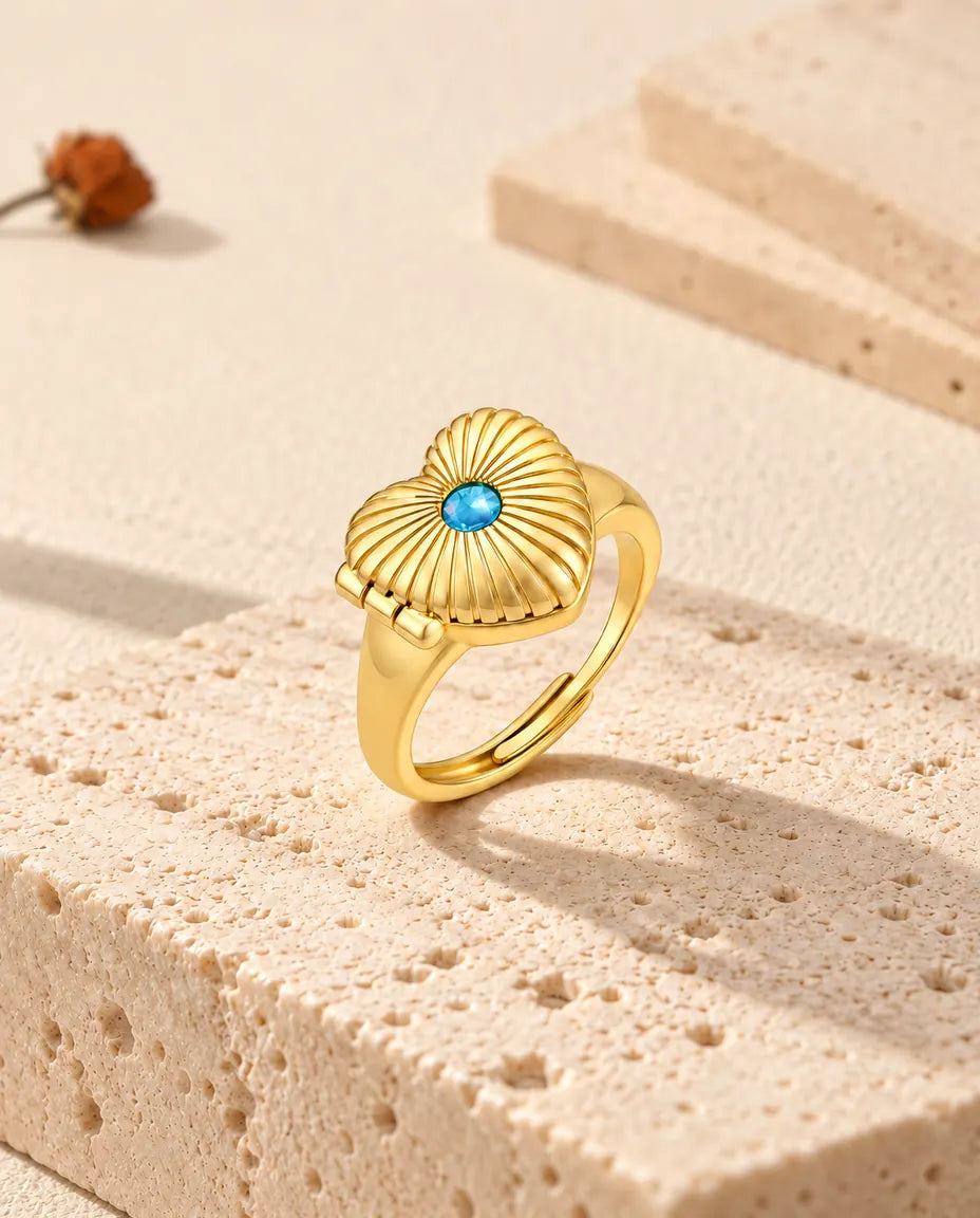 Geschlossener Herz-Medaillon-Ring, aufrecht auf einem Travertinblock