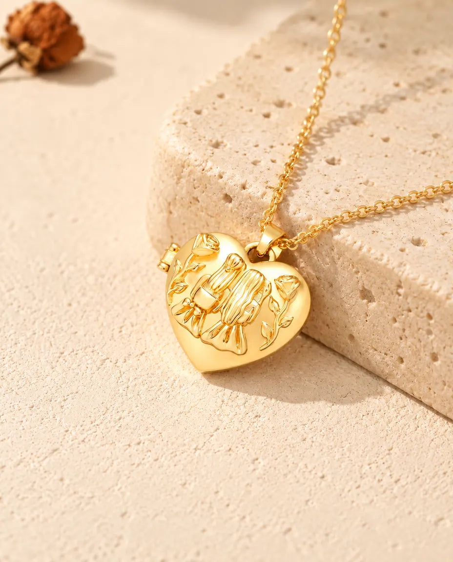 Goldfarbenes Herz-Foto-Medaillon mit zwei Schwestern als Kette an einem Travertinblock