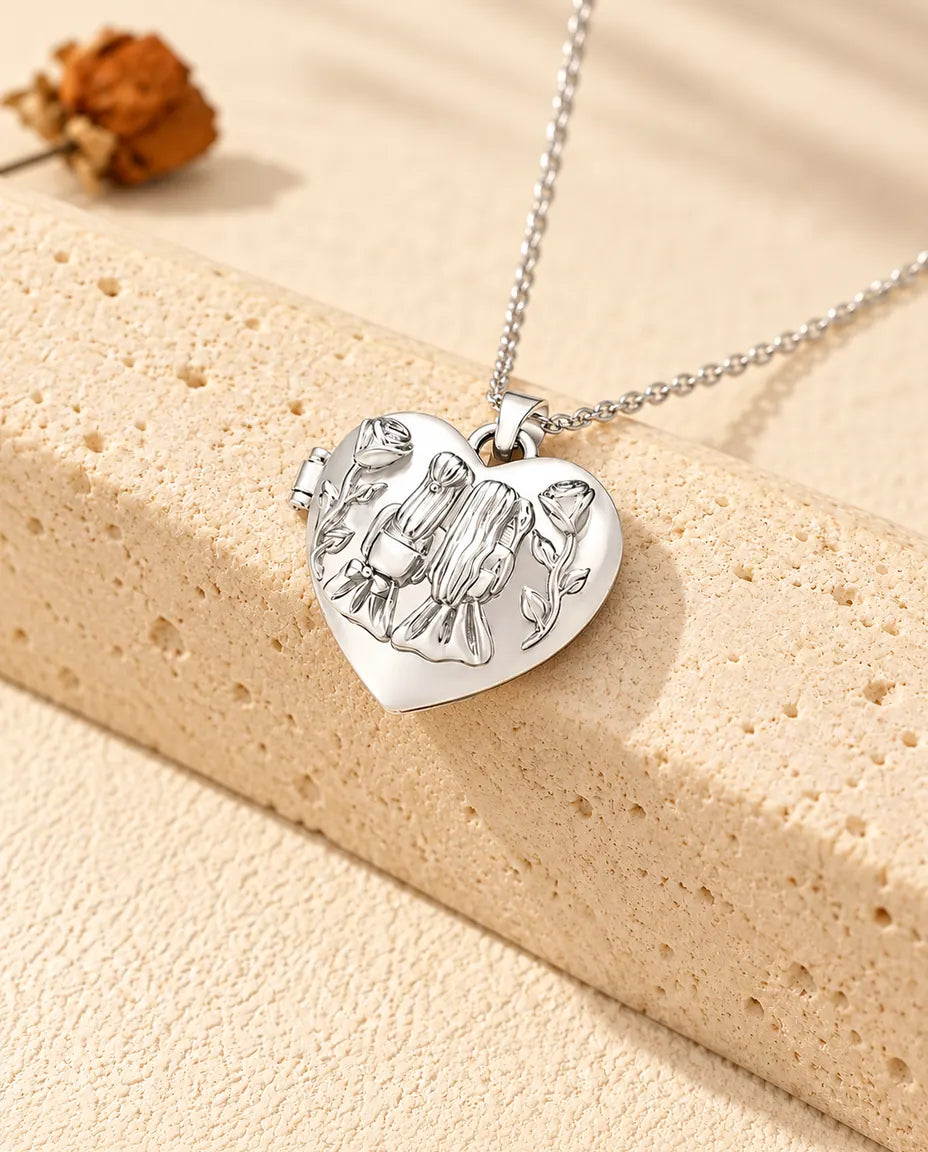 Silberfarbenes Herz-Foto-Medaillon mit zwei Schwestern als personalisierte Kette, an einen Travertinblock gelehnt