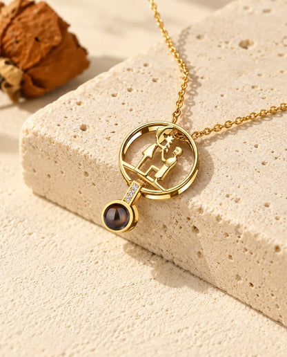 Personalisierte goldfarbene Heiratsantrag-Kette mit Bild im Stein und kniendem Paar auf Travertin