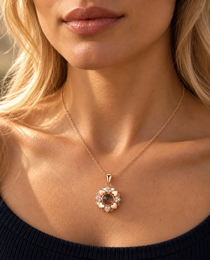 Frau im marineblauen Strickoberteil trägt die roségoldfarbene Herzblumen-Kette