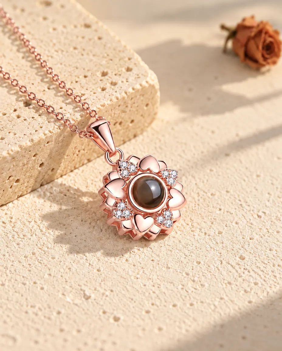 Roségoldfarbene Herzblumen-Kette im warmen Sonnenlicht auf Gips
