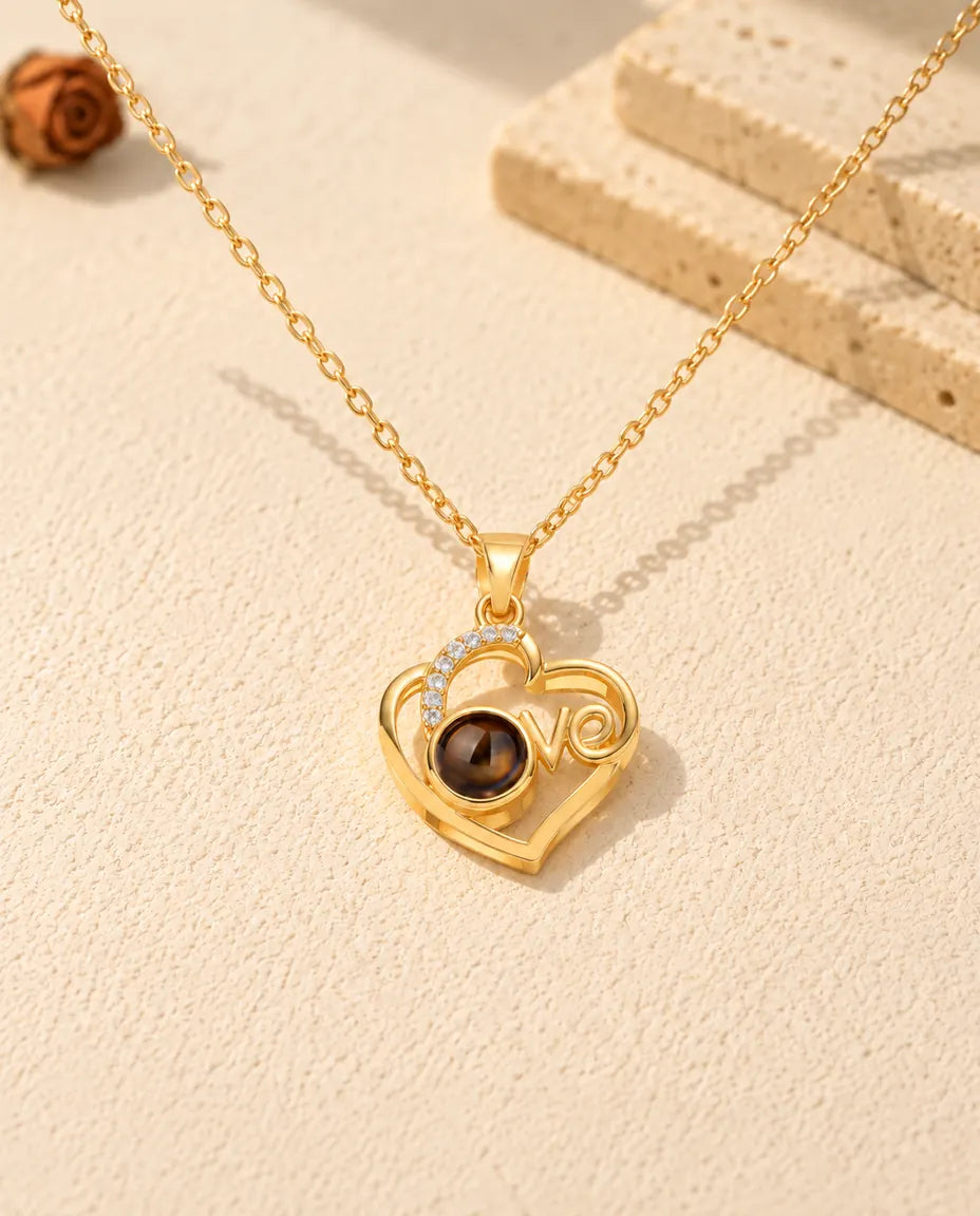 Goldfarbener Love-Herz Anhänger von vorne, der braune Projektionsstein bildet das o