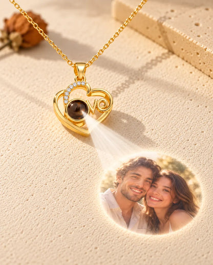 Goldfarbene Love-Herz Kette projiziert ein Paarfoto aus dem Stein auf cremefarbenen Putz