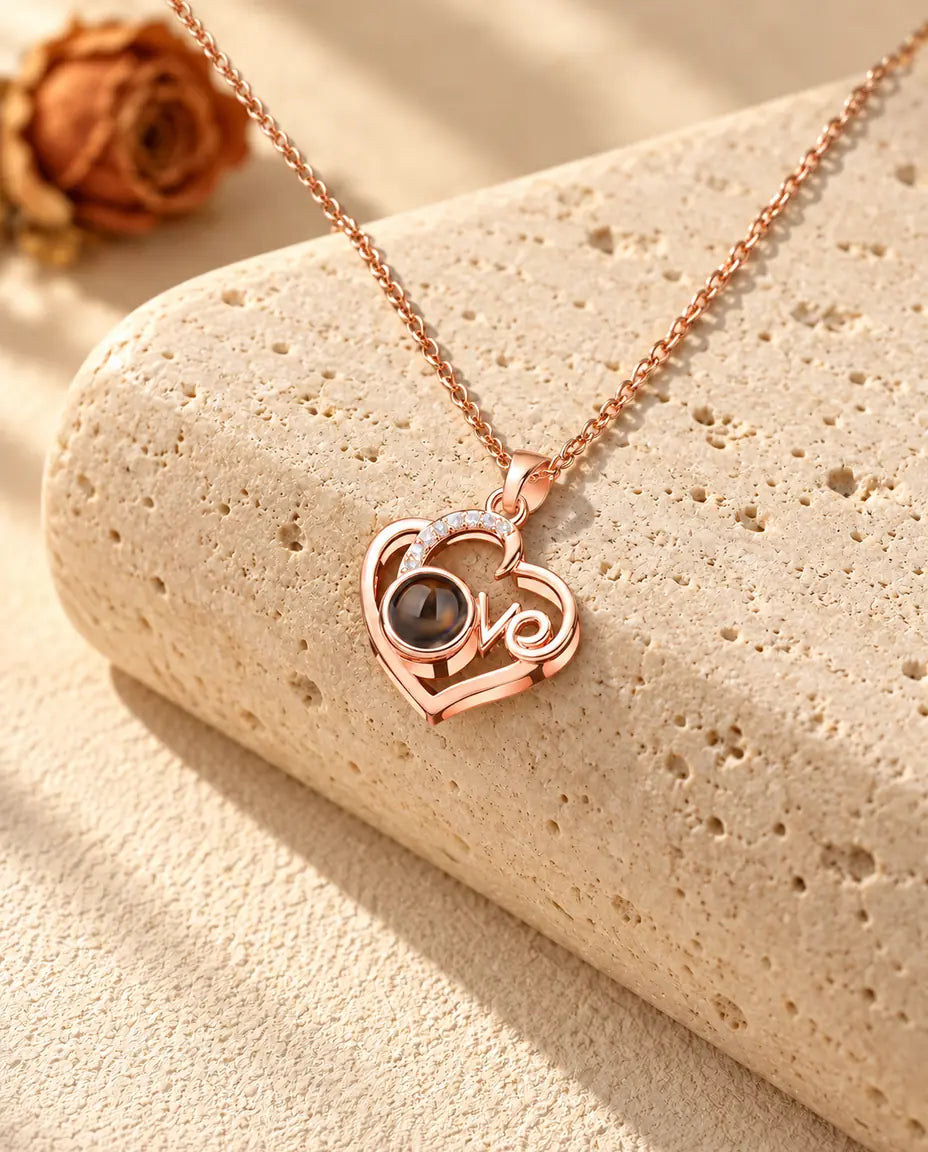 Roségoldfarbene Love-Herz Kette mit Bild im Stein auf Travertin im warmen Sonnenlicht