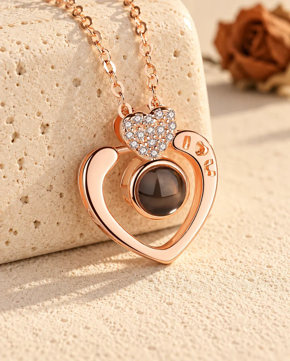 Personalisierte roségoldfarbene Kette mit offenem Herz und Bild im Stein an einem Travertinblock