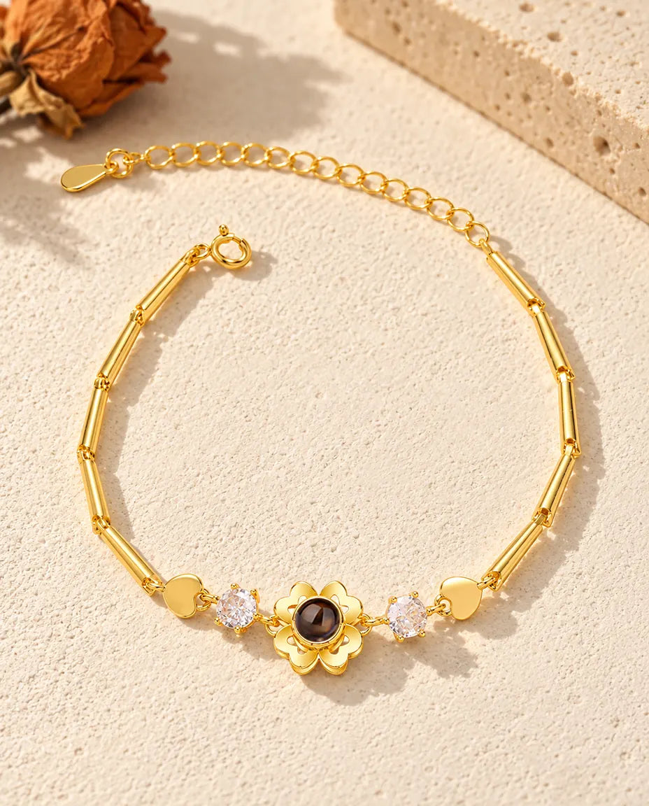 Draufsicht auf das goldfarbene Kleeblatt-Armband mit Bild im Stein
