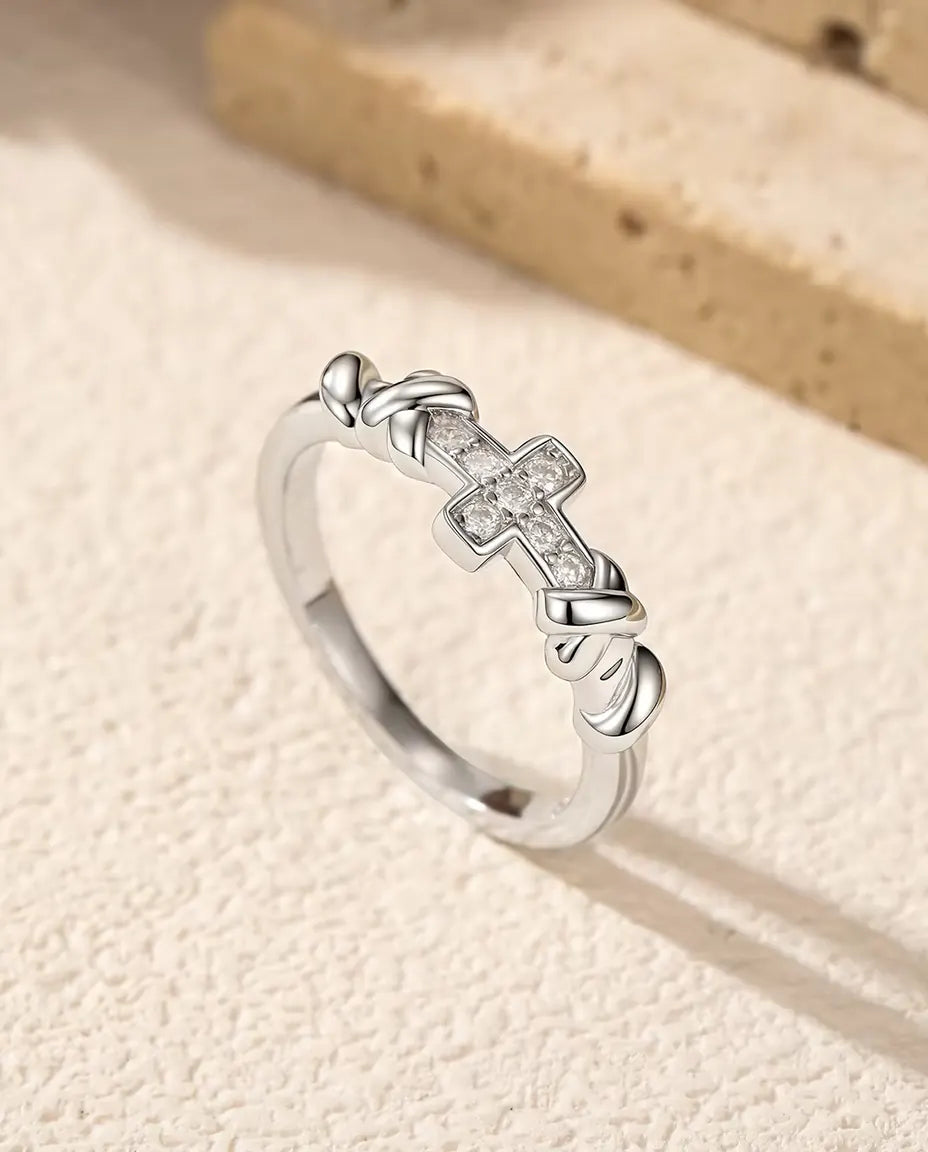 Kreuz Moissanit Ring aus 925 Sterlingsilber - aufrecht stehend auf heller Strukturfläche
