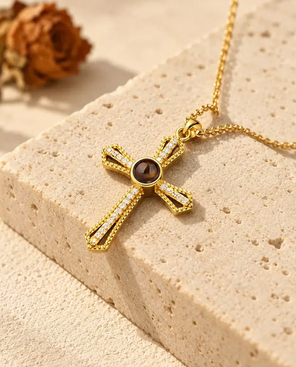 Goldfarbenes Kreuz mit offenen Armen und einer Reihe Zirkonia auf Travertin