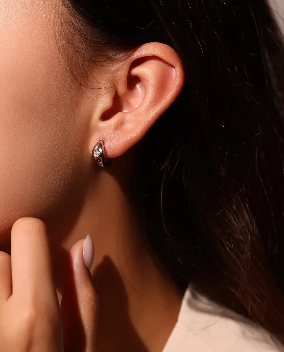 Moissanit Creolen im Asscher-Schliff aus 925 Sterlingsilber - am Ohr des Models getragen, Hand nah am Gesicht