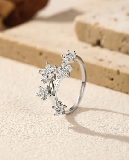 Moissanit Ring mit Sternen aus 925 Sterlingsilber - aufrecht stehend auf heller Strukturfläche