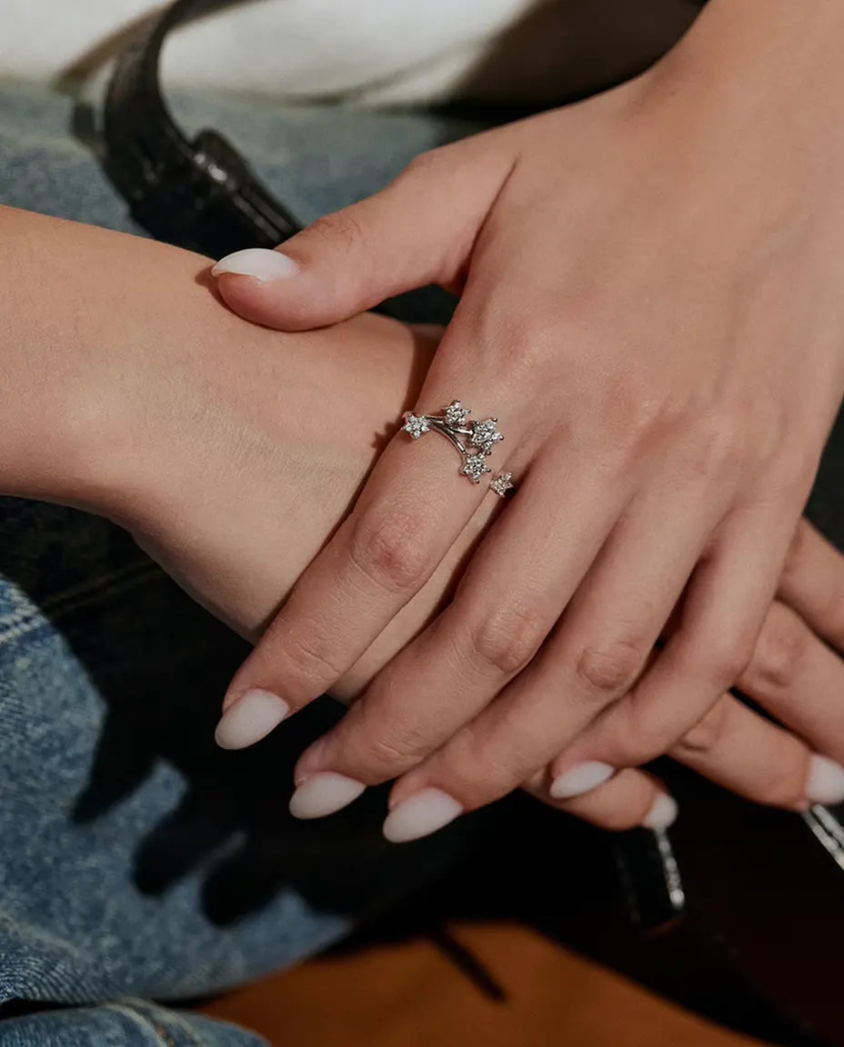 Moissanit Ring mit Sternen aus 925 Sterlingsilber - an der Hand des Models getragen, auf Jeansstoff ruhend