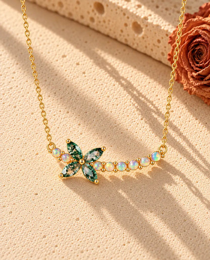 Moosachat Blumen Kette aus vergoldetem 925 Sterlingsilber - auf heller Strukturfläche neben einem Travertinblock liegend
