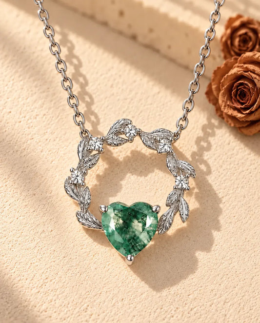 Moosachat Herz Kette aus 925 Sterlingsilber - auf heller Strukturfläche neben einem Travertinblock liegend