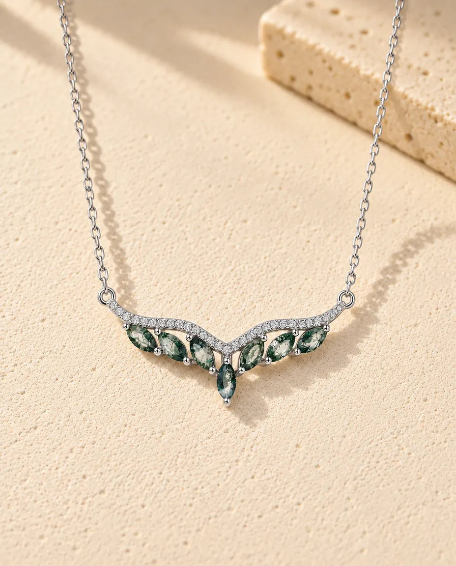 Moosachat Kette aus 925 Sterlingsilber - auf heller Strukturfläche neben einem Travertinblock liegend