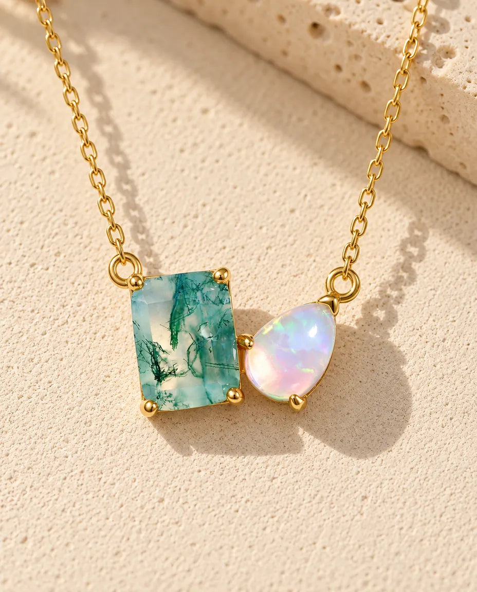 Moosachat und Opal Kette aus vergoldetem 925 Sterlingsilber - auf heller Strukturfläche neben einem Travertinblock liegend