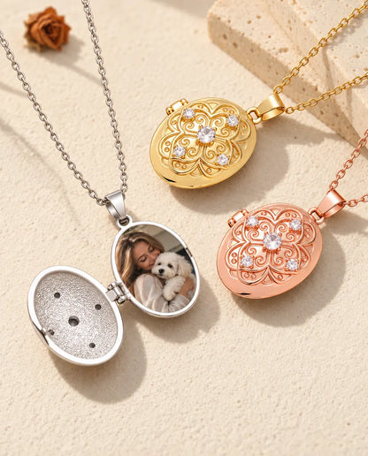 Aufgeklapptes silberfarbenes ovales Medaillon mit Familienfoto neben goldfarbenem und roségoldfarbenem Medaillon