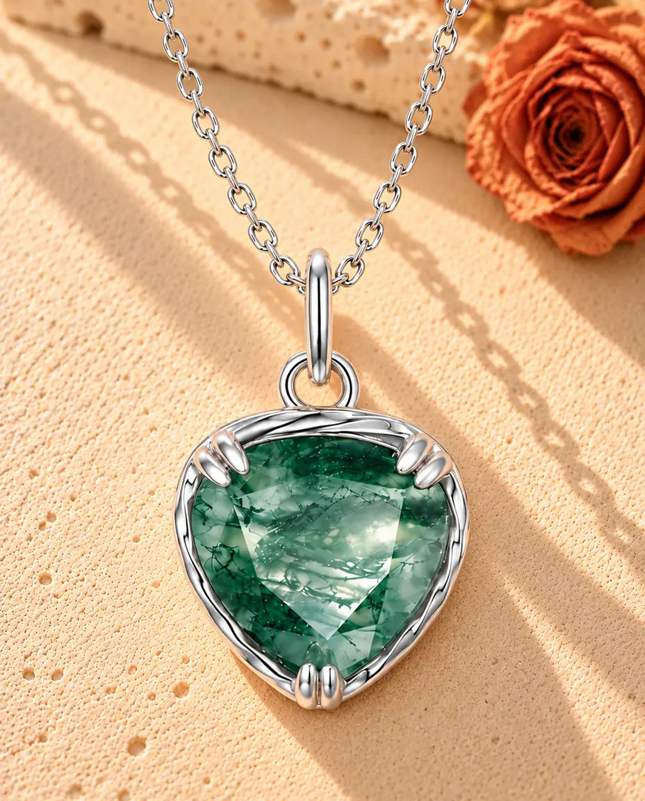 Herz Moosachat Kette aus 925 Sterlingsilber - auf heller Strukturfläche neben einem Travertinblock liegend