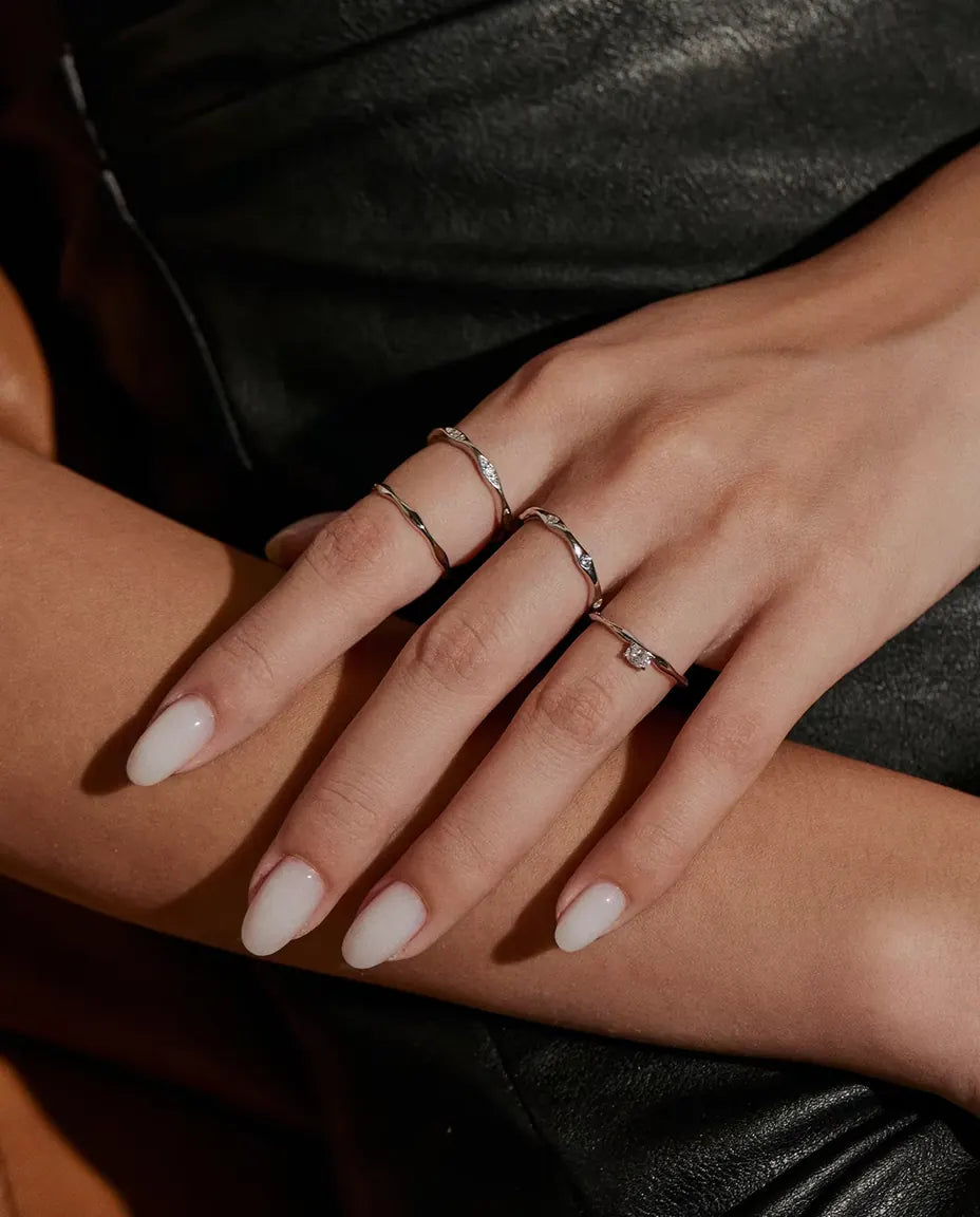 Welliger Ring aus 925 Sterlingsilber - zusammen mit weiteren Ringen getragen, Hände übereinander
