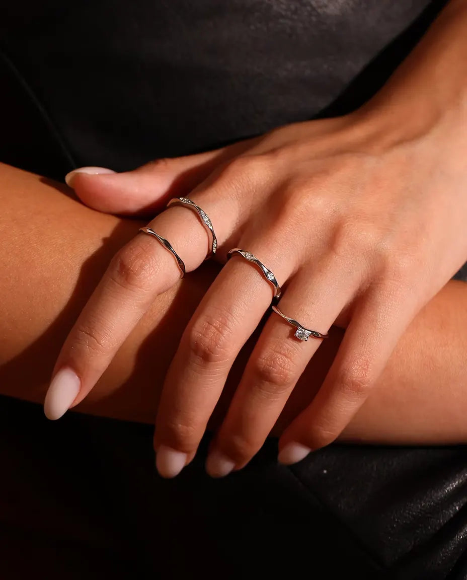 Welliger Ring aus 925 Sterlingsilber - zusammen mit weiteren Ringen getragen, Nahaufnahme der Finger